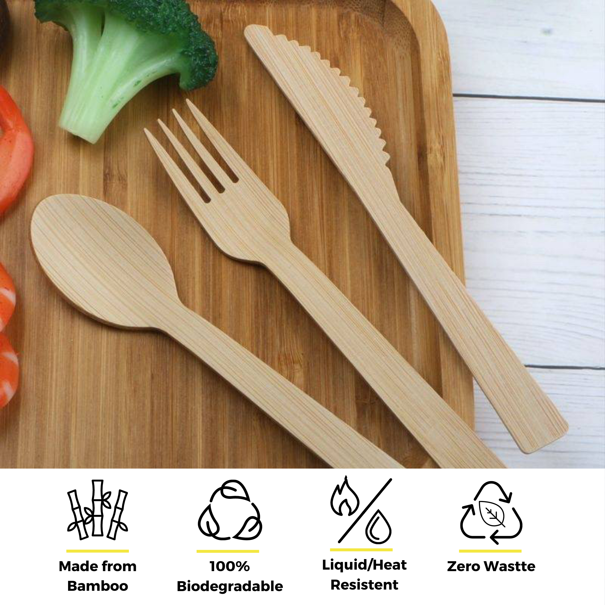 An elegant bamboo cutlery set by Holy City Straw Co., arranged on a wooden cutting board next to slices of fresh tomato and broccoli. Accompanying eco-friendly icons highlight the utensils' features: made from bamboo, 100% biodegradable, liquid/heat resistant, and zero waste.