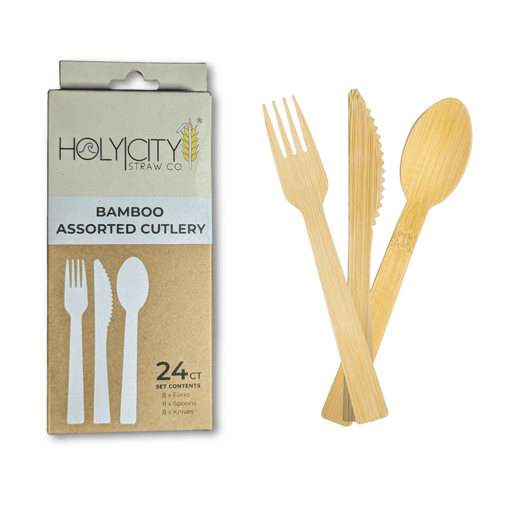 A package of Holy City Straw Co. eco-friendly bamboo assorted cutlery is on display. The box, which contains a 24-piece set comprising eight forks, eight spoons, and eight knives, emphasizes sustainable dining. The utensils are shown to the right, with one of each type — a fork, a knife, and a spoon — arranged in an overlapping fashion to showcase their natural bamboo texture and design.
