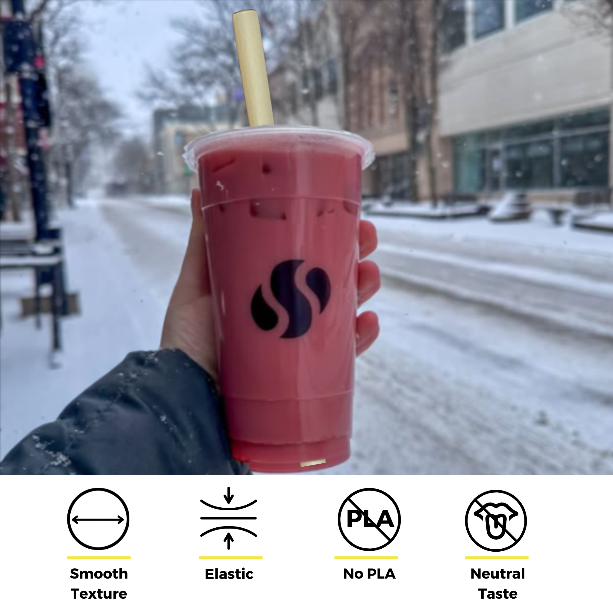 Holy City bamboo fiber straw in a bright pink smoothie held in a snowy urban setting, highlighting straw features: elastic, smooth texture, PLA-free, and neutral taste.