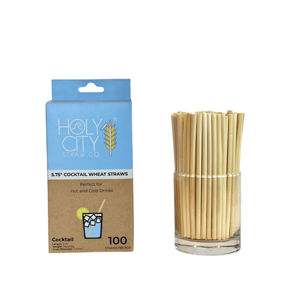 Holy City Straw Co. box of 100 5.75-inch cocktail wheat straws, perfect for hot and cold drinks, displayed alongside a glass filled with the straws.