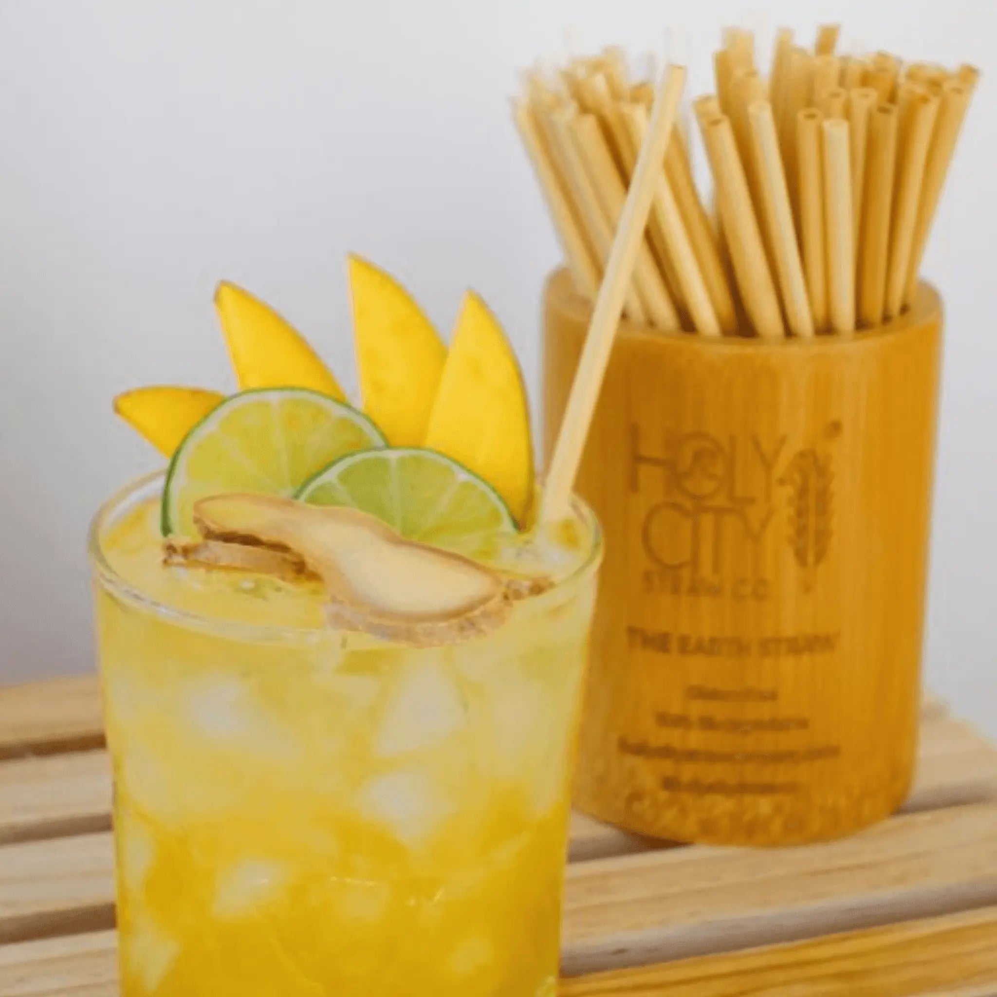 Holy City Straw Company Branded small Bamboo Straw Holder next to citrus drink