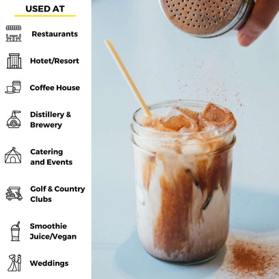 Hand sprinkling cinnamon onto iced coffee used at a myriad of businesses