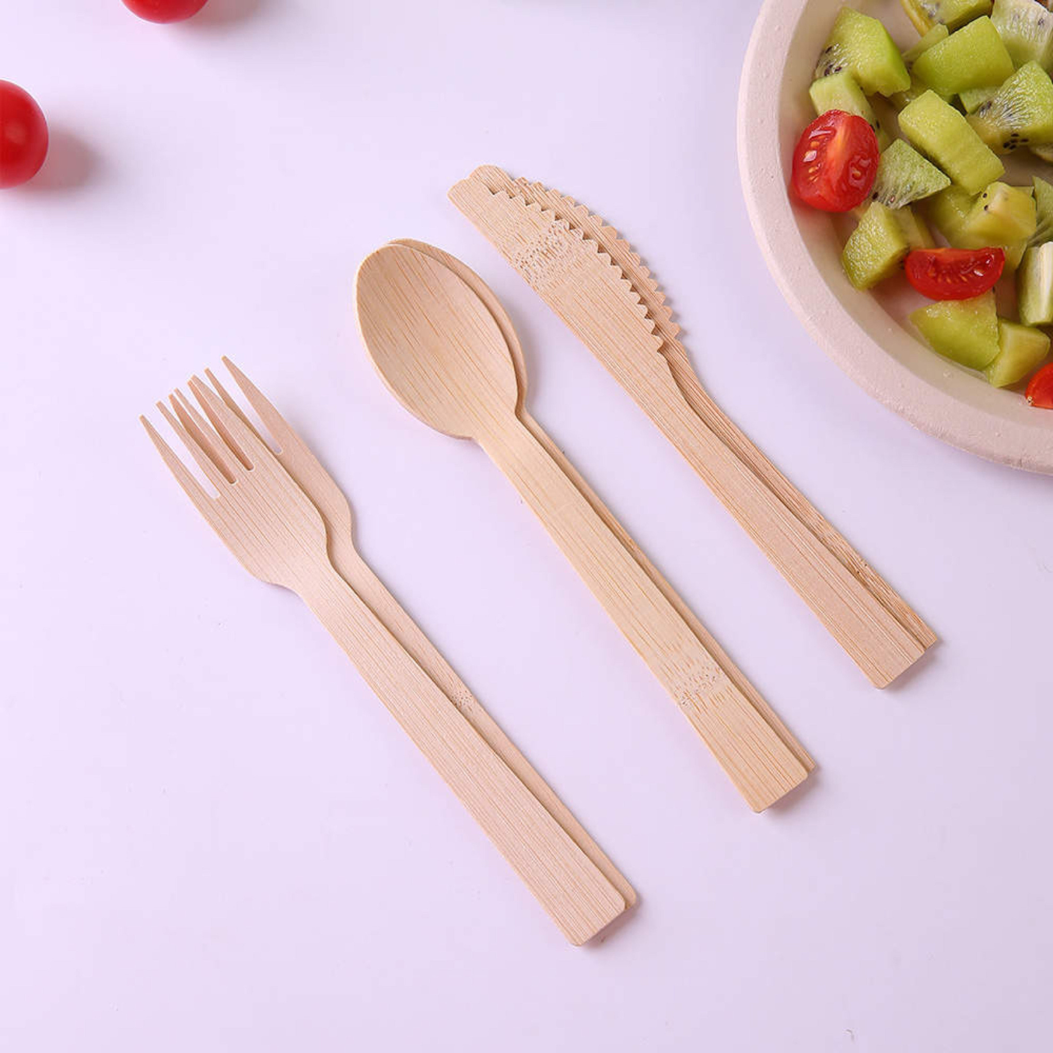 Two set of Holy City Straw Co bamboo fork knife spoon next to plate