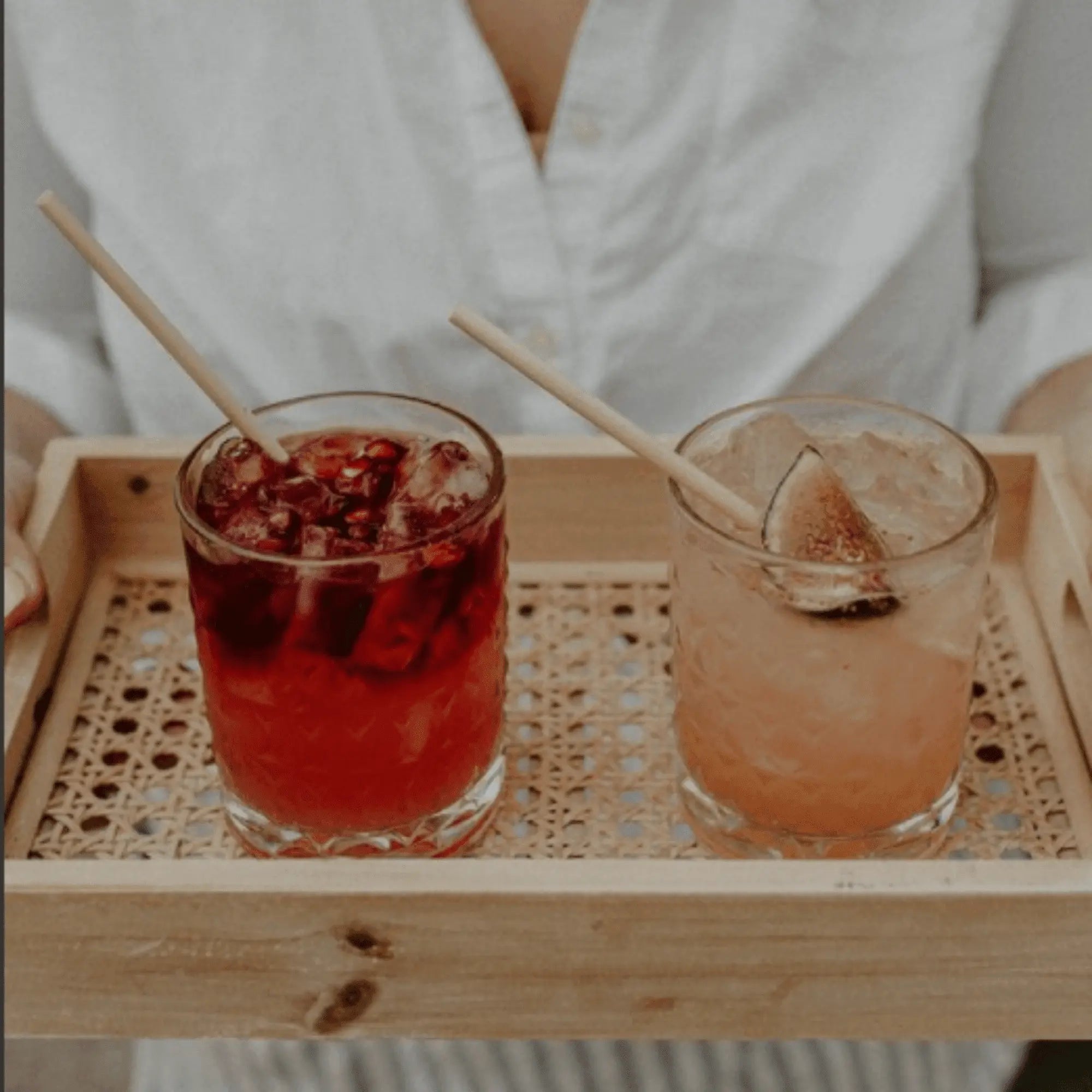 Bartender presenting two wheat stem cocktails